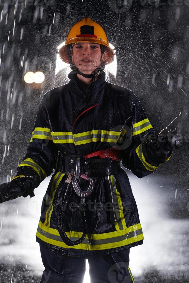 A determined female firefighter in a professional uniform striding through the dangerous, rainy night on a daring rescue mission, showcasing her unwavering bravery and commitment to saving lives. photo