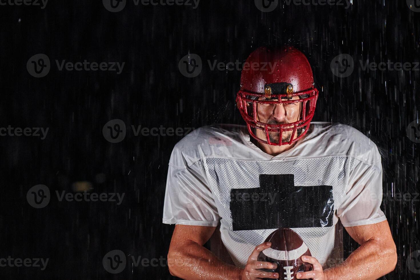 American Football Field. Lonely Athlete Warrior Standing on a Field Holds his Helmet and Ready to Play. Player Preparing to Run, Attack and Score Touchdown. photo