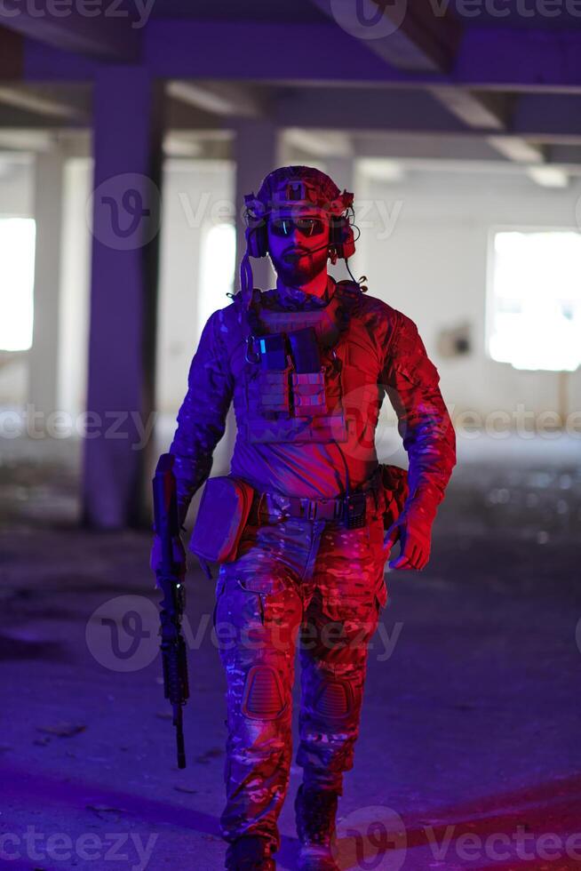A professional soldier undertakes a perilous mission in an abandoned building illuminated by neon blue and purple lights photo