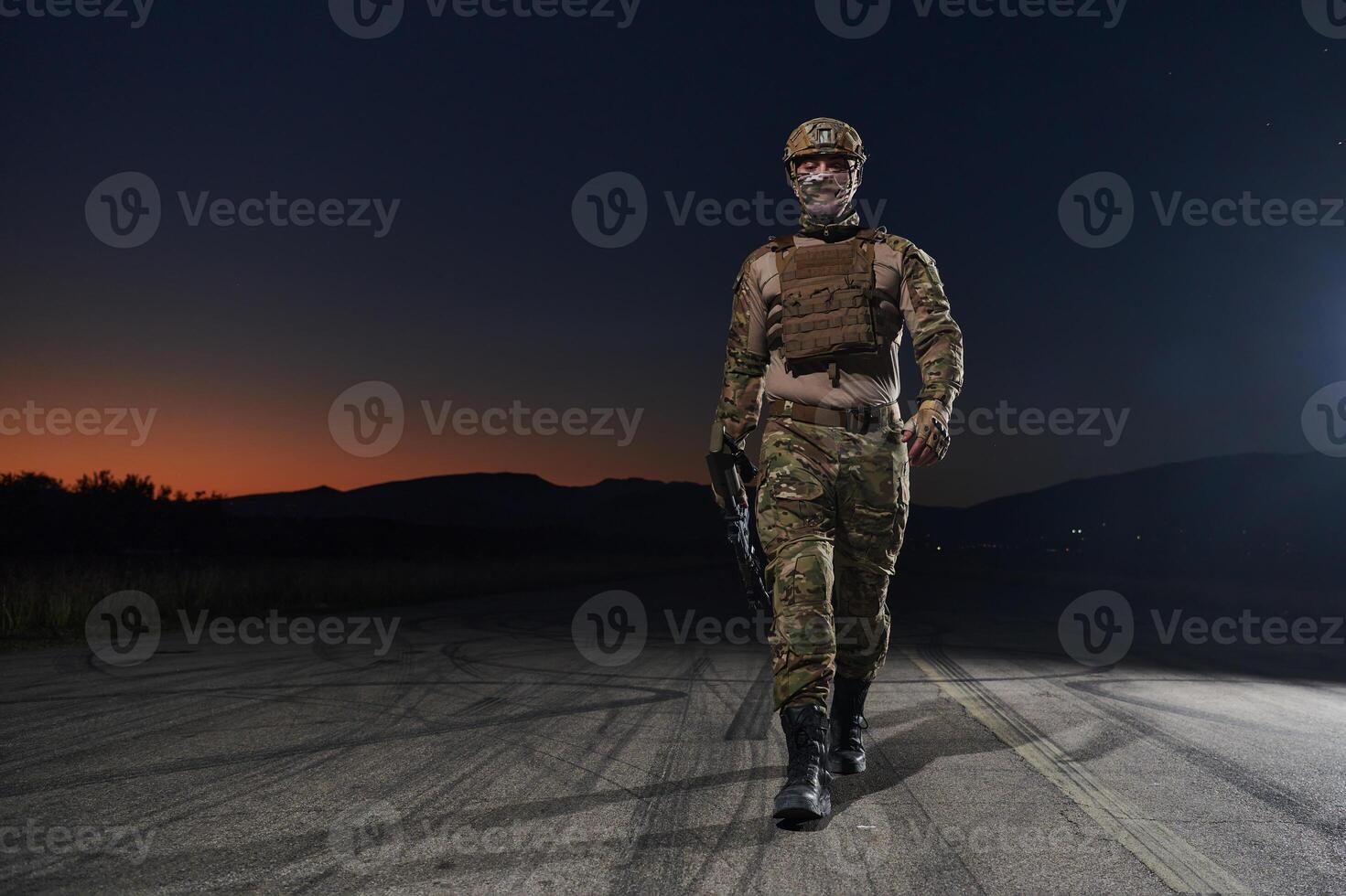 A professional soldier in full military gear striding through the dark night as he embarks on a perilous military mission photo