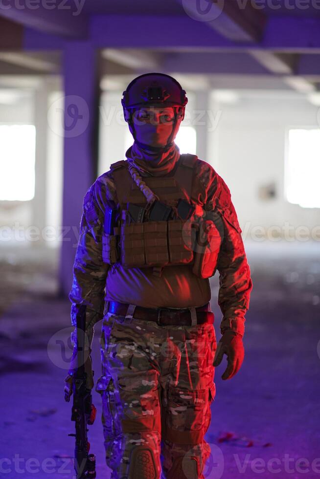A professional soldier undertakes a perilous mission in an abandoned building illuminated by neon blue and purple lights photo