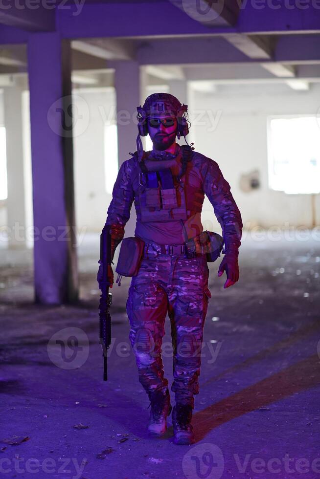 A professional soldier undertakes a perilous mission in an abandoned building illuminated by neon blue and purple lights photo