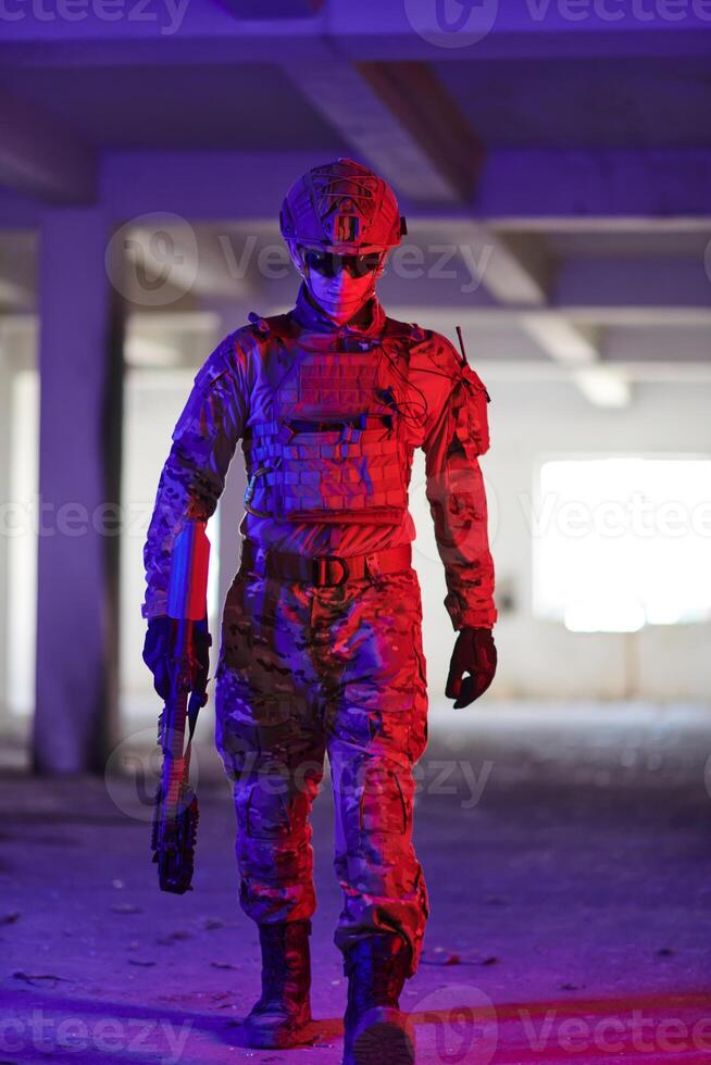 A professional soldier undertakes a perilous mission in an abandoned building illuminated by neon blue and purple lights photo