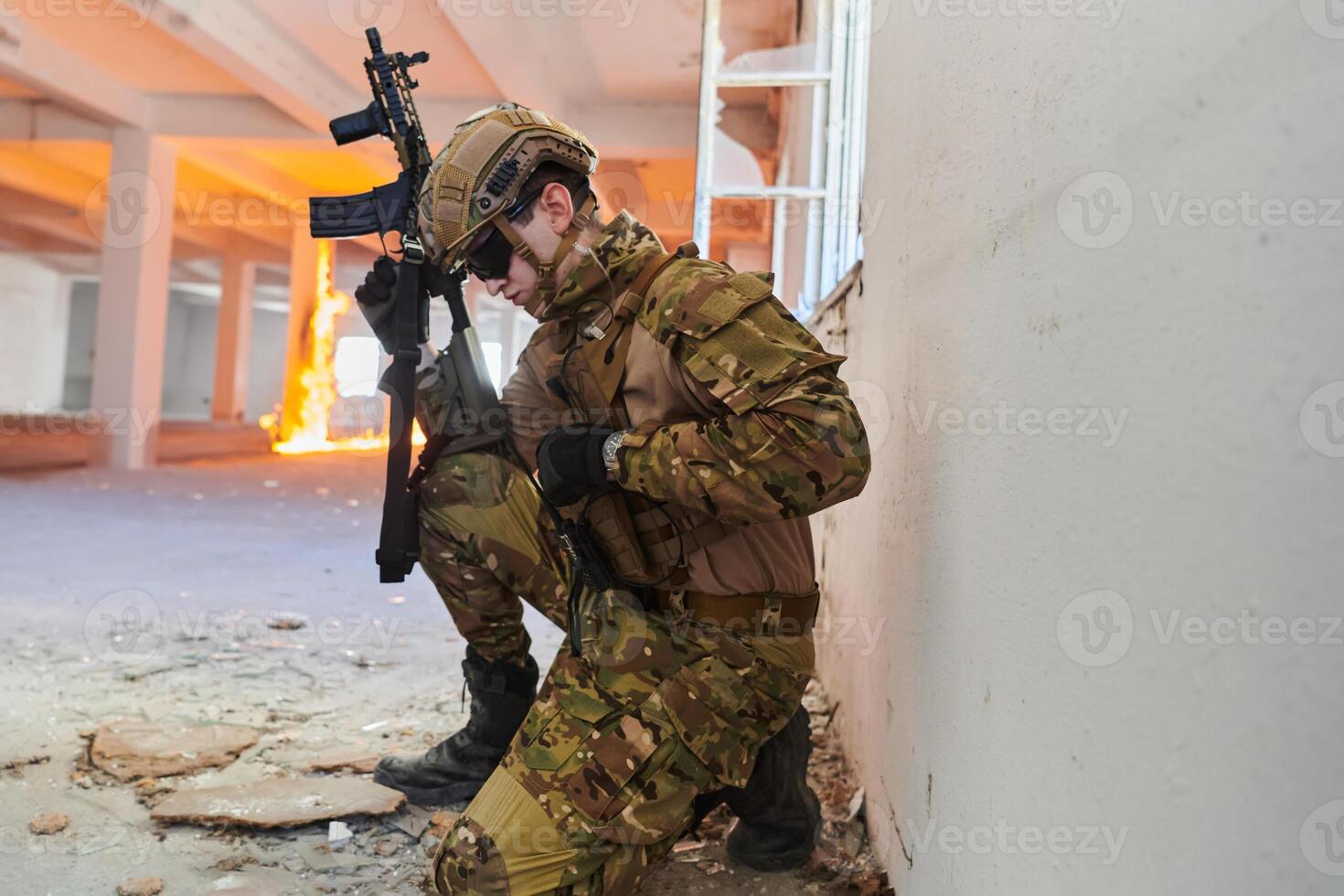 Soldier in action near window changing magazine and take cover photo