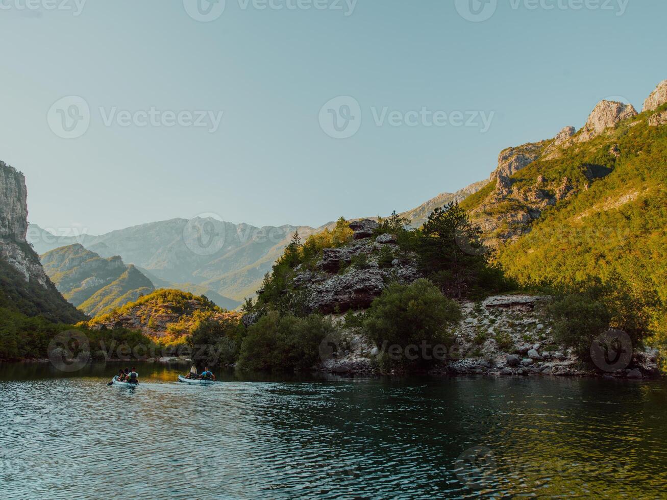 A group of friends enjoying having fun and kayaking while exploring the calm river, surrounding forest and large natural river canyons photo