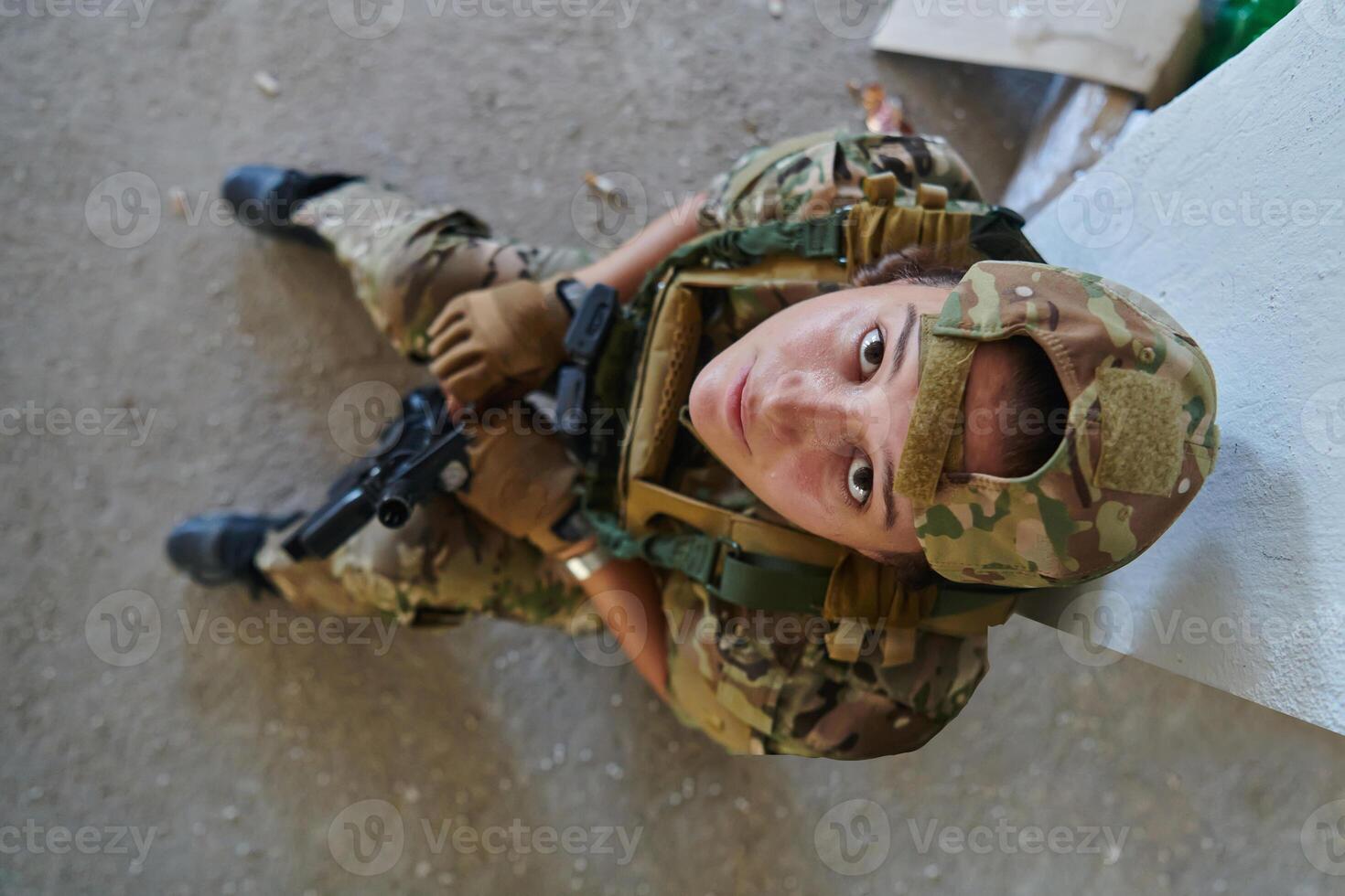 A woman in a professional military uniform sits in an abandoned building, ready for a dangerous mission, exuding bravery and determination photo