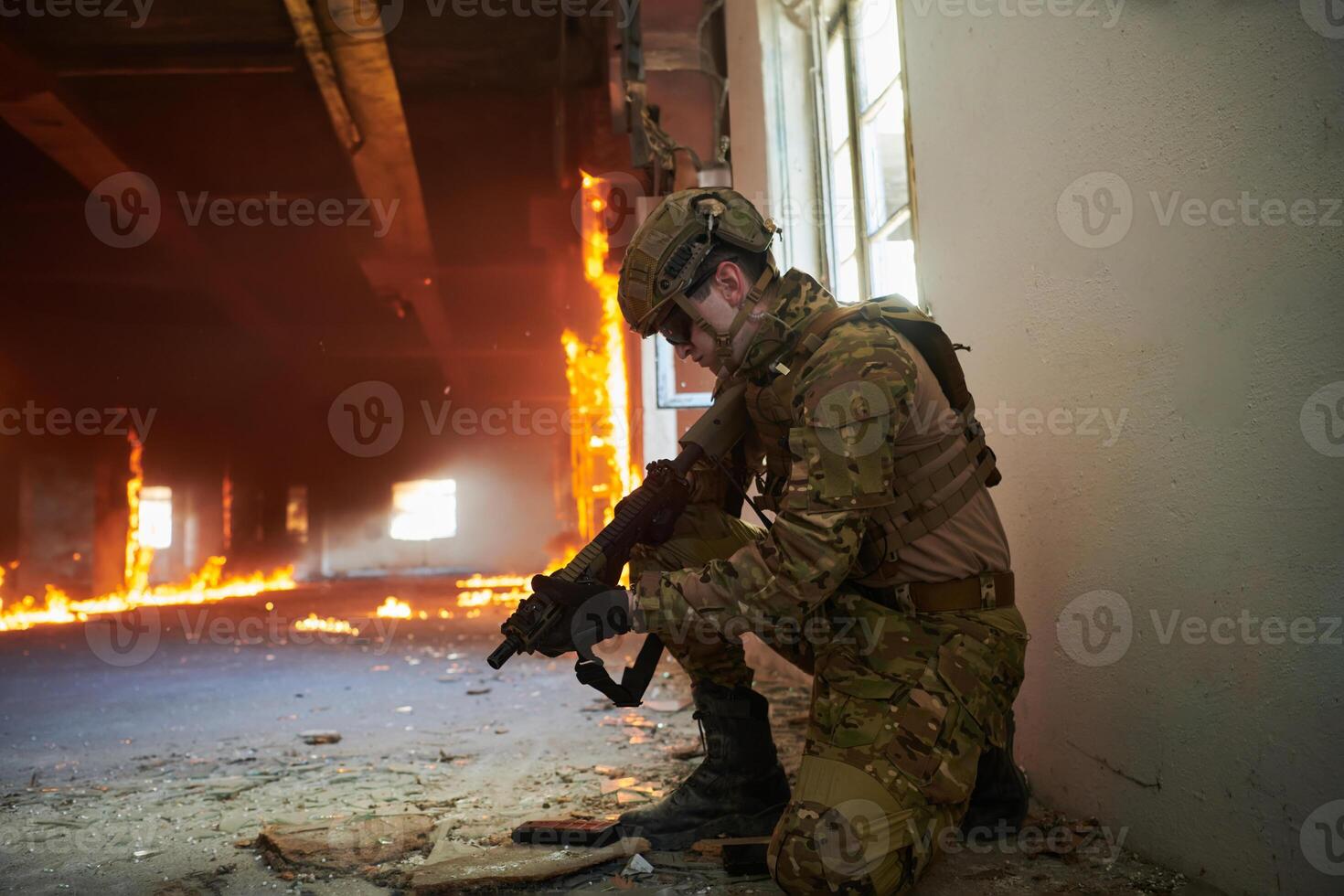 Soldier in action near window changing magazine and take cover photo