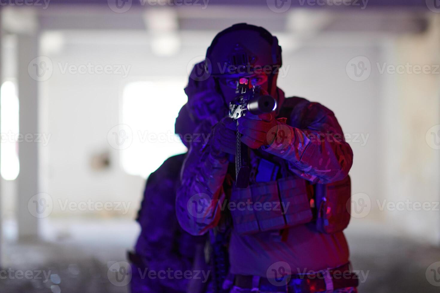 A professional soldier undertakes a perilous mission in an abandoned building illuminated by neon blue and purple lights photo