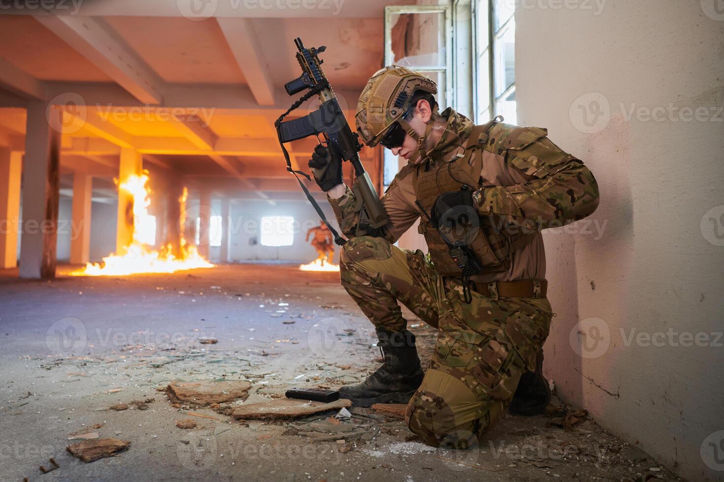 Soldier in action near window changing magazine and take cover photo