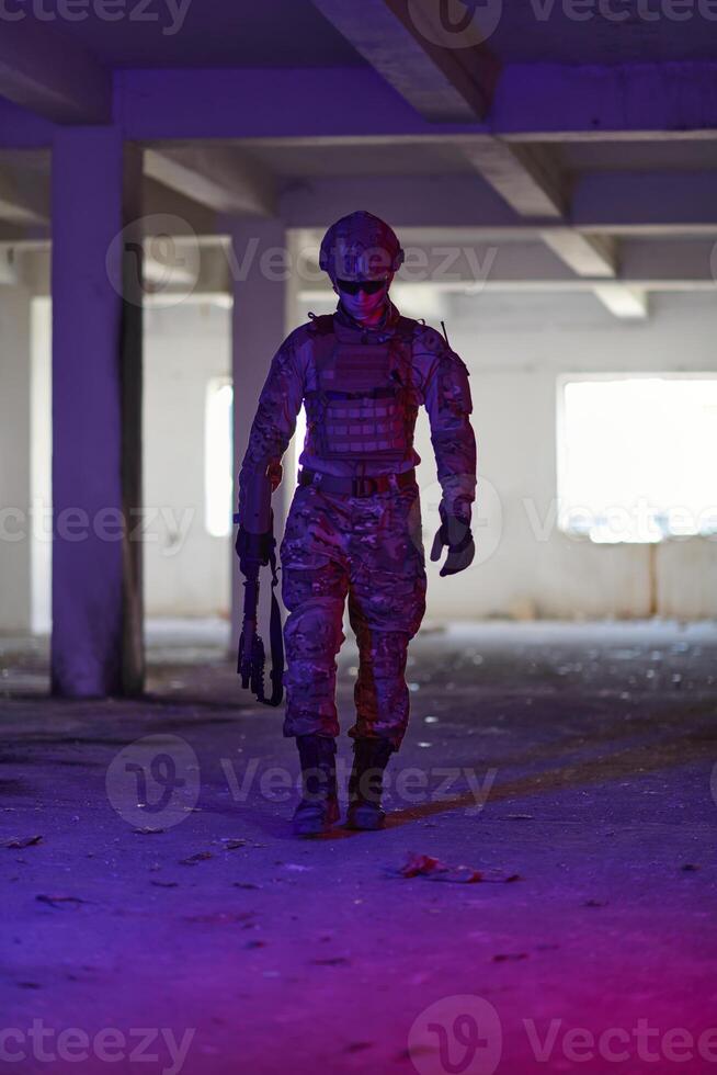 A professional soldier undertakes a perilous mission in an abandoned building illuminated by neon blue and purple lights photo