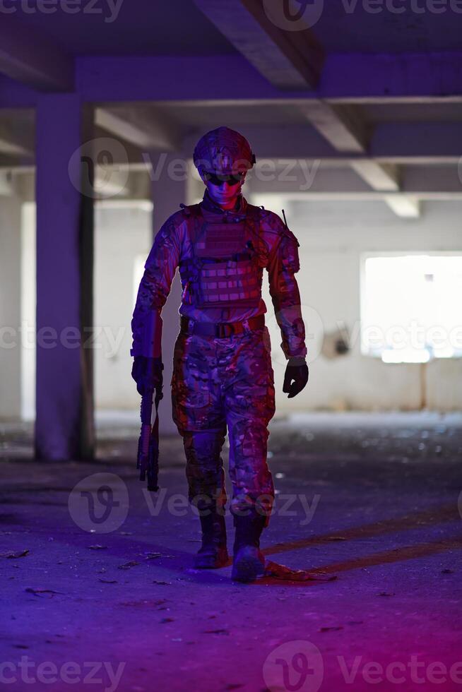 A professional soldier undertakes a perilous mission in an abandoned building illuminated by neon blue and purple lights photo