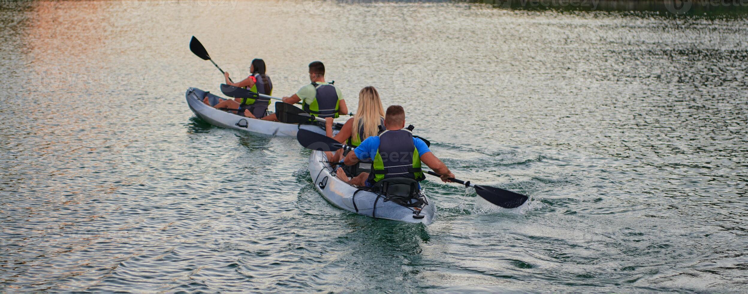 A group of friends enjoying having fun and kayaking while exploring the calm river, surrounding forest and large natural river canyons photo