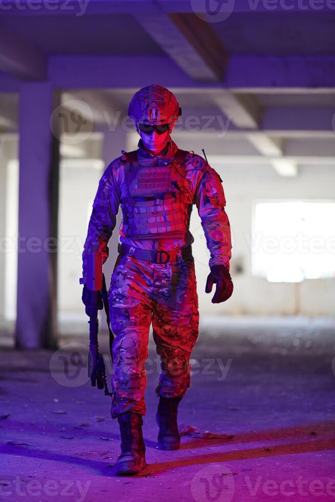 A professional soldier undertakes a perilous mission in an abandoned building illuminated by neon blue and purple lights photo