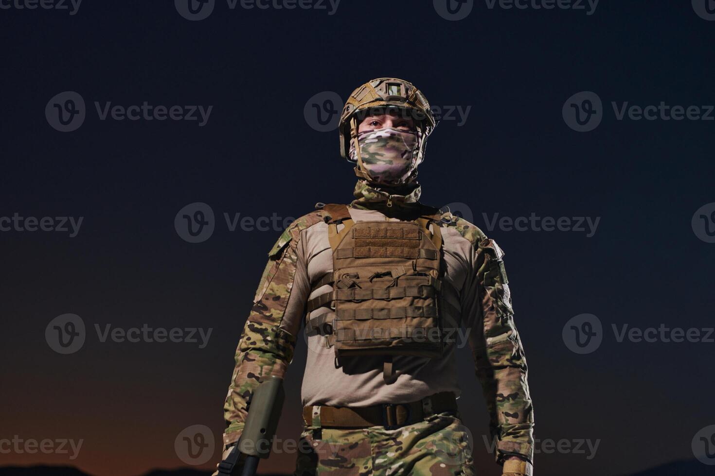 A professional soldier in full military gear striding through the dark night as he embarks on a perilous military mission photo