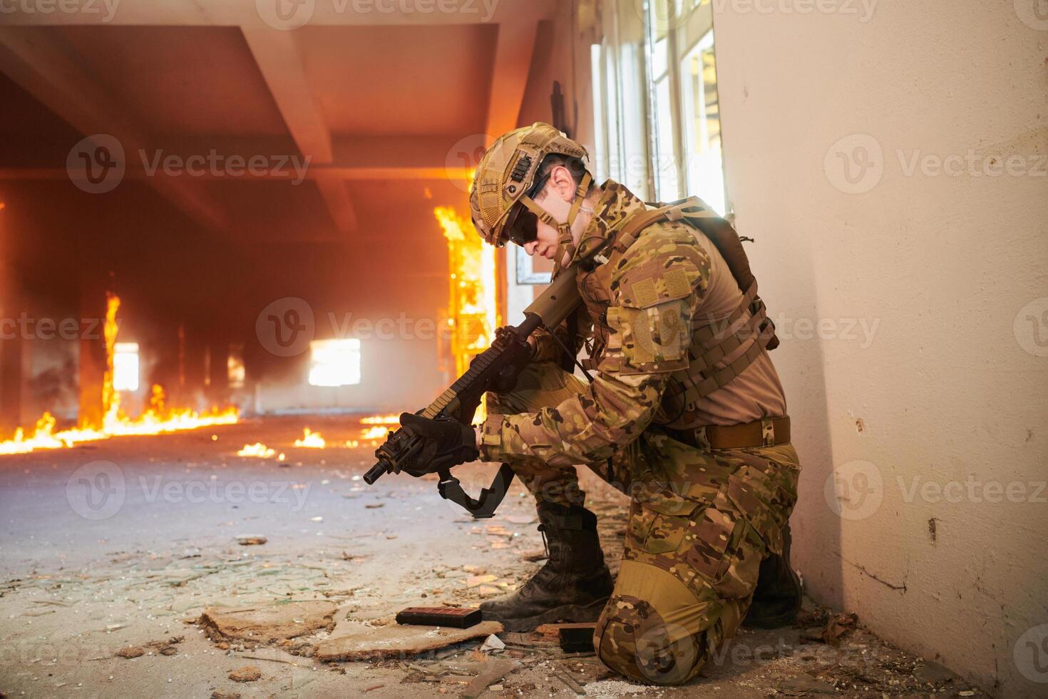 Soldier in action near window changing magazine and take cover photo