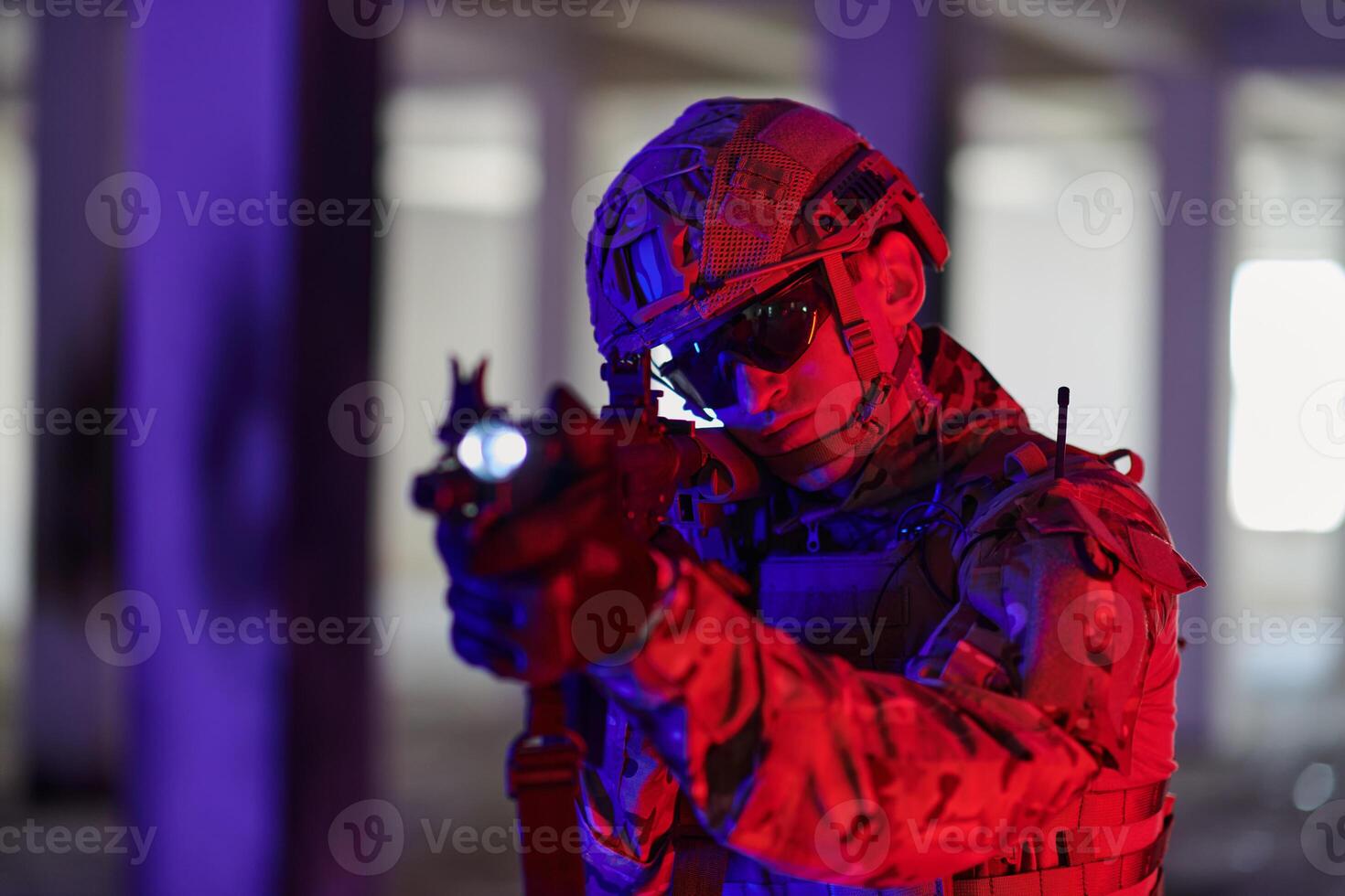 A professional soldier undertakes a perilous mission in an abandoned building illuminated by neon blue and purple lights photo