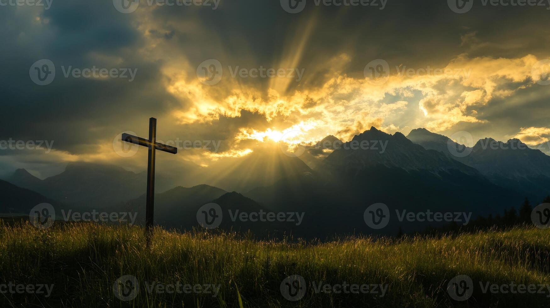 Sunset over mountain peaks with cross in foreground photo