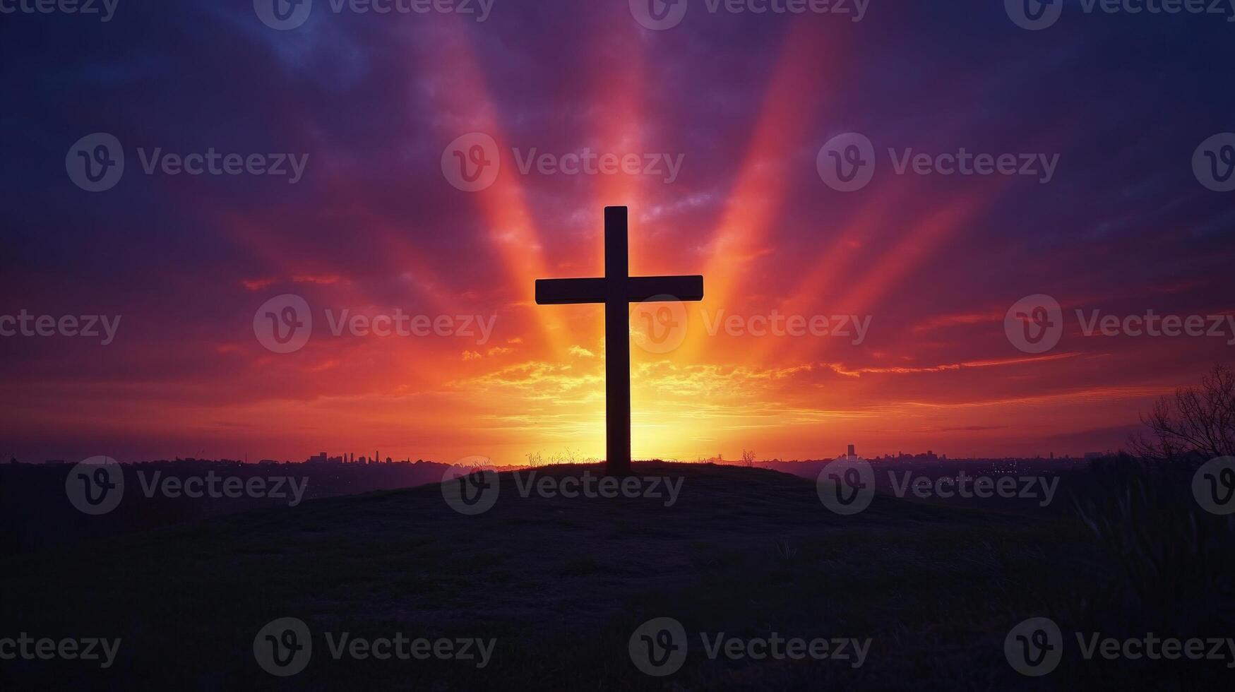 Dramatic sunset silhouette of cross on hill with radiant sky photo