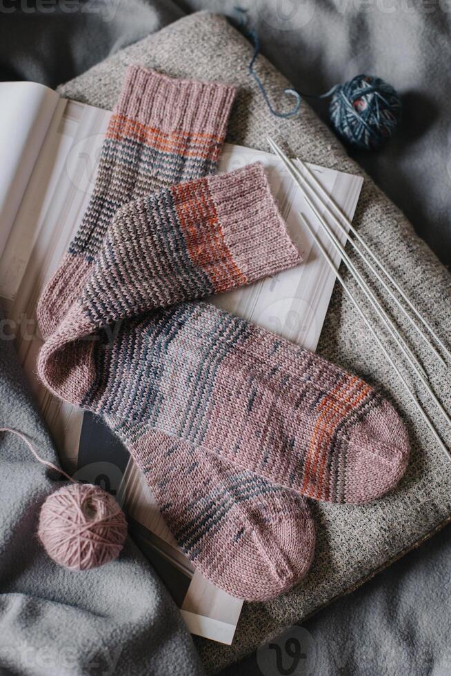 Cosy hand knitted socks with needles and yarn ball. photo