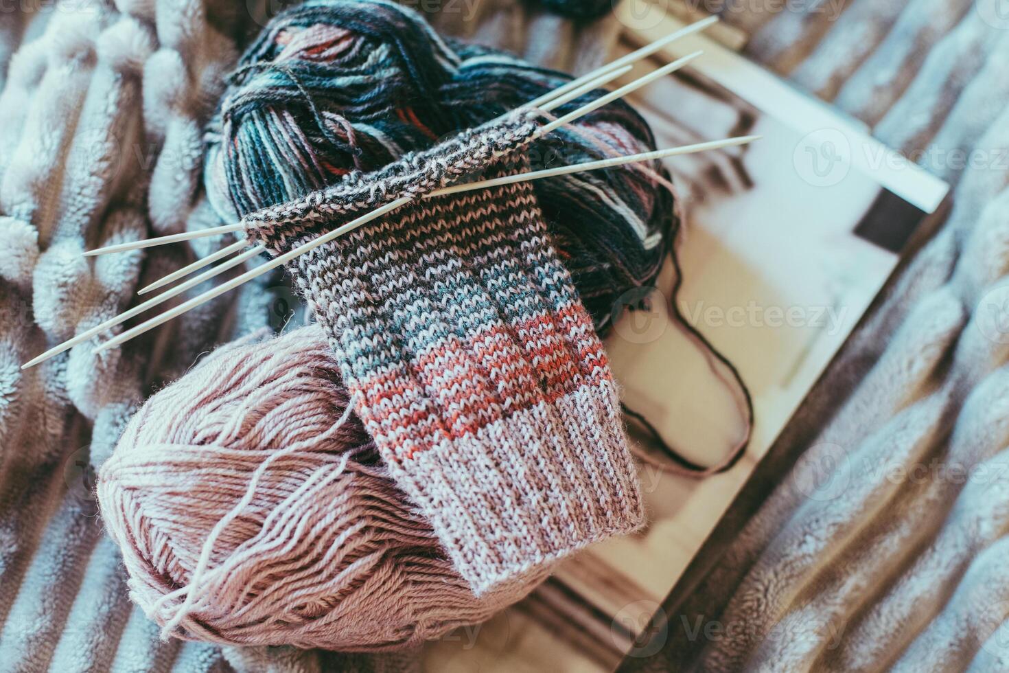 Hand knitted socks with needles and woolen yarn ball. Concept for handmade and hygge slow life. photo