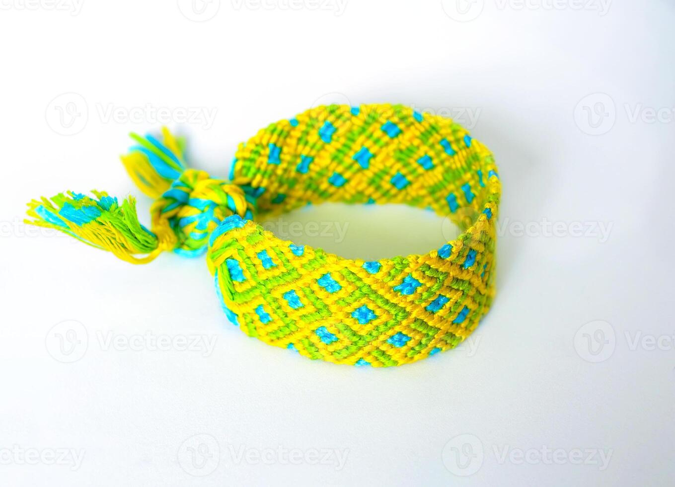 yellow green DIY friendship bracelets handmade of embroidery bright thread with knots isolated on white background photo
