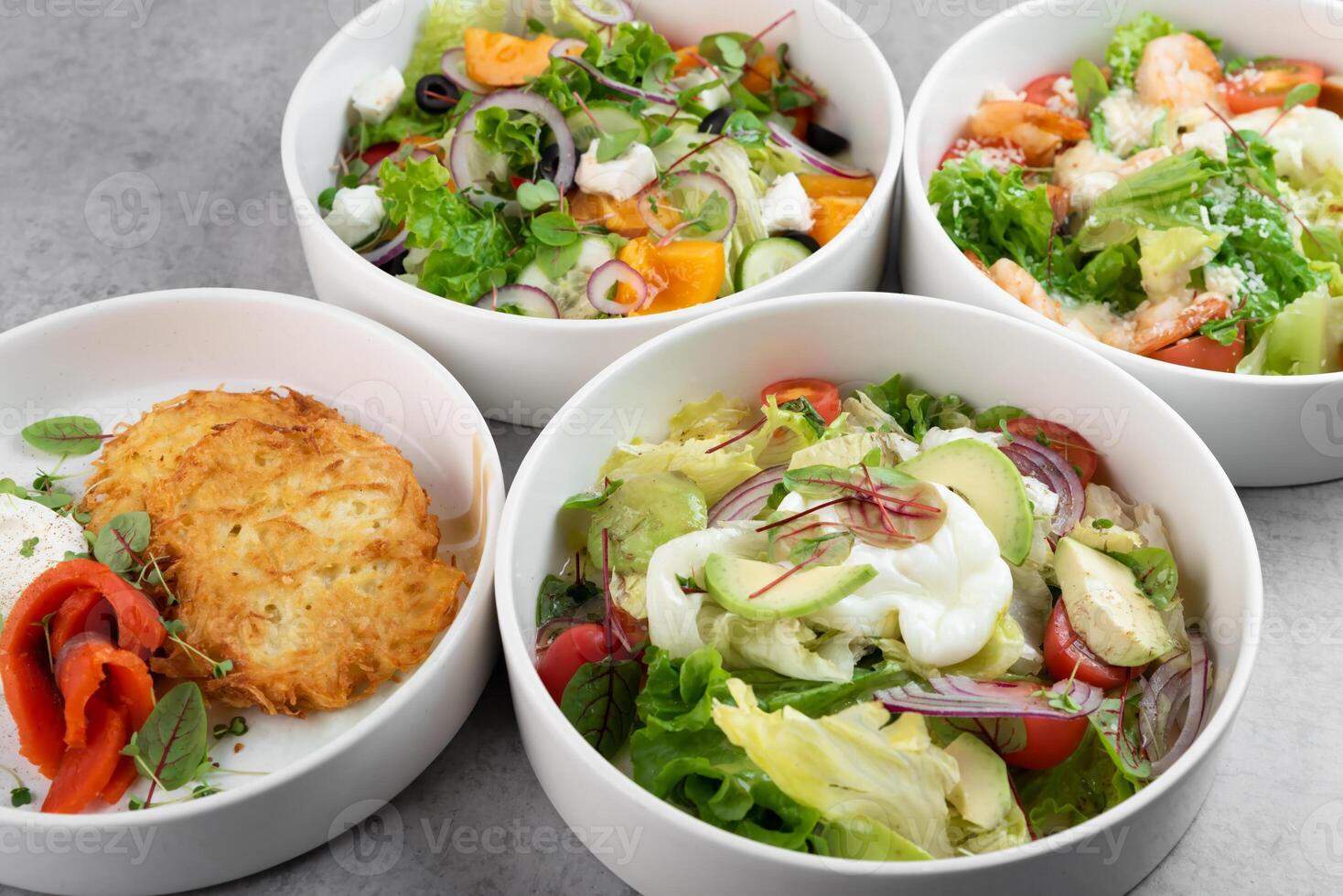 3different vegetable salads and slavic draniki potato pancakes on gray marble background photo