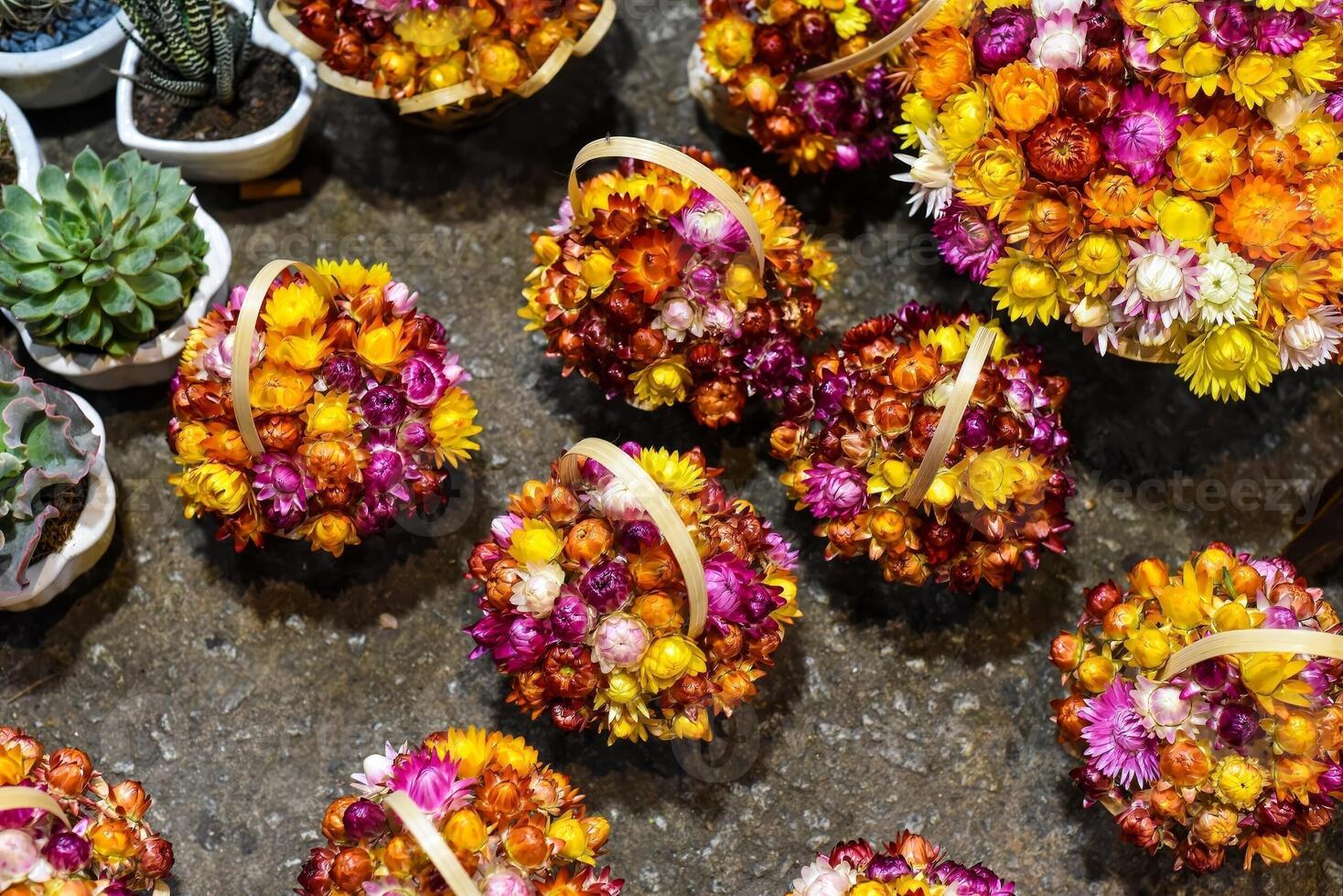 Creative baskets with Xerochrysum bracteatum, commonly known as the golden everlasting or strawflower in night market in Da Lat in Vietnam photo