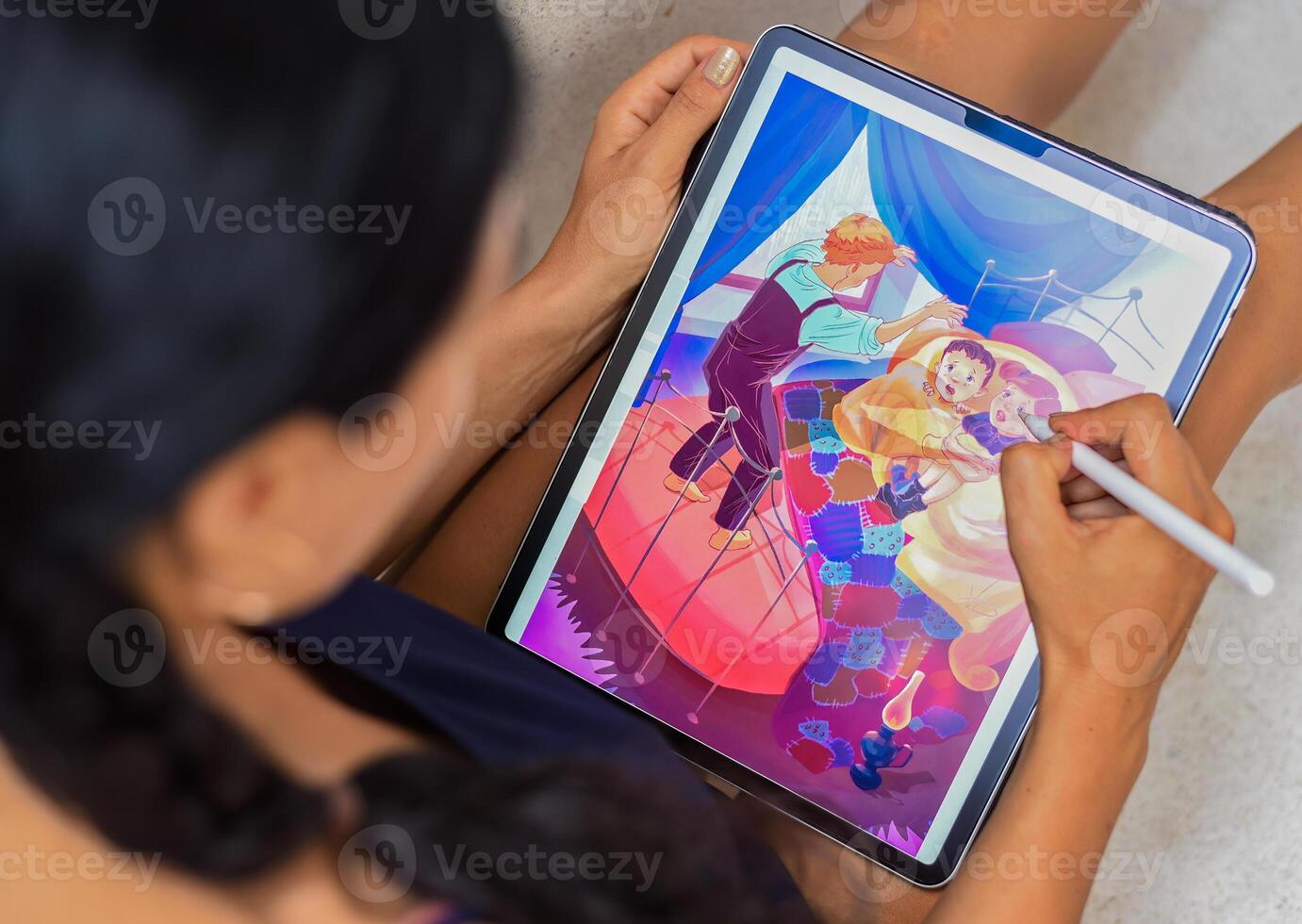 Brunette woman artist and illustrator drawing with electronical tablet and stylus, by using touchscreen photo