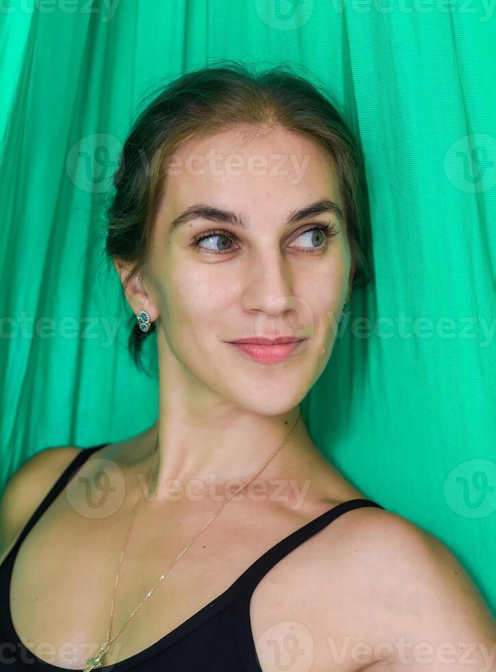 Portrait of young russian woman 31 year old looking side against green background photo