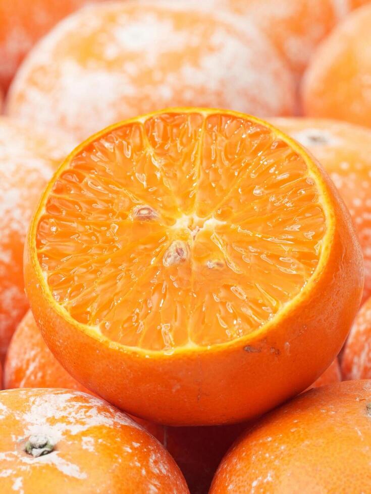 A pile of oranges, showcasing various types such as mandarin oranges, valencia oranges, and clementines photo
