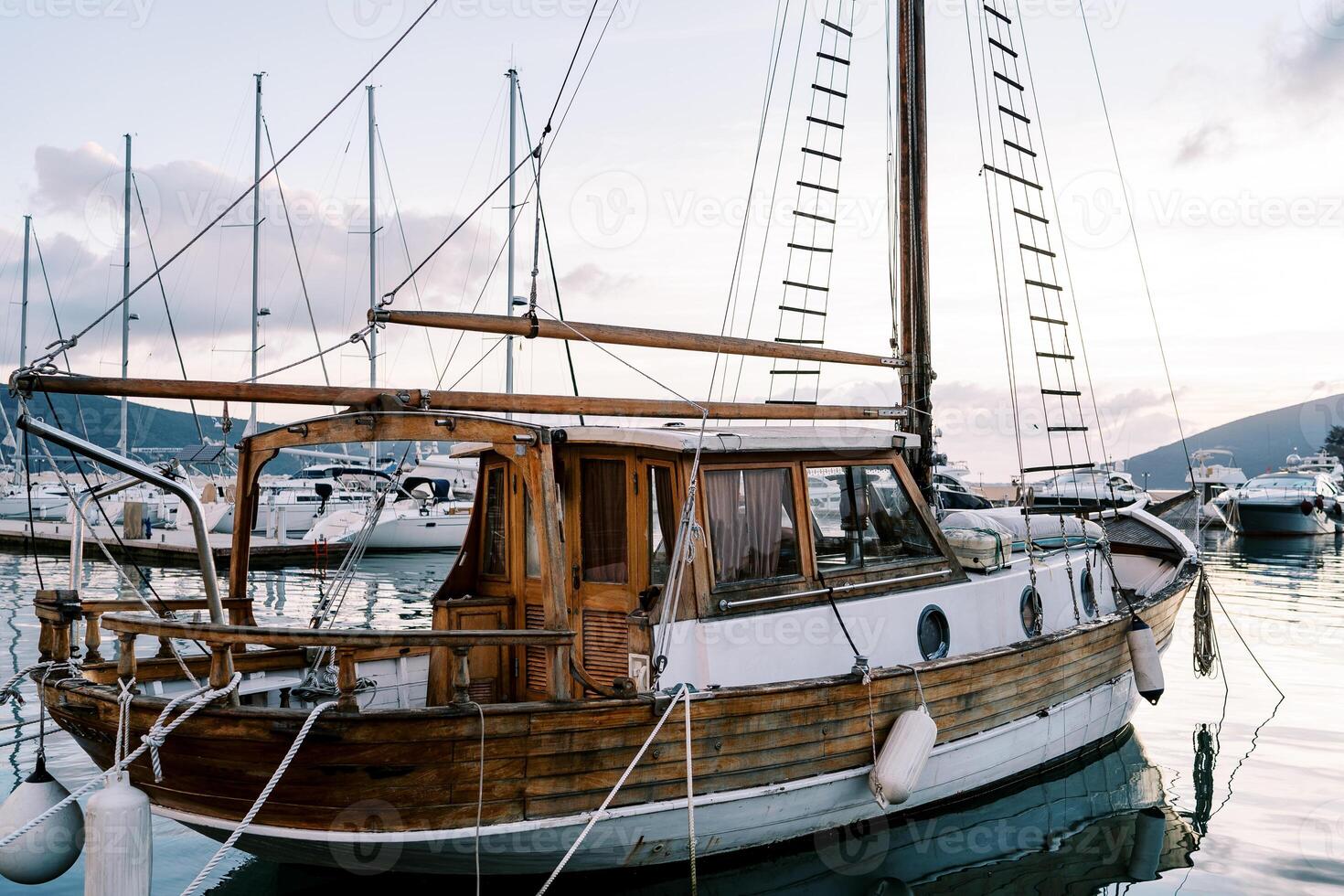 Wooden sailing yacht moored at the pier against the backdrop of mountains photo
