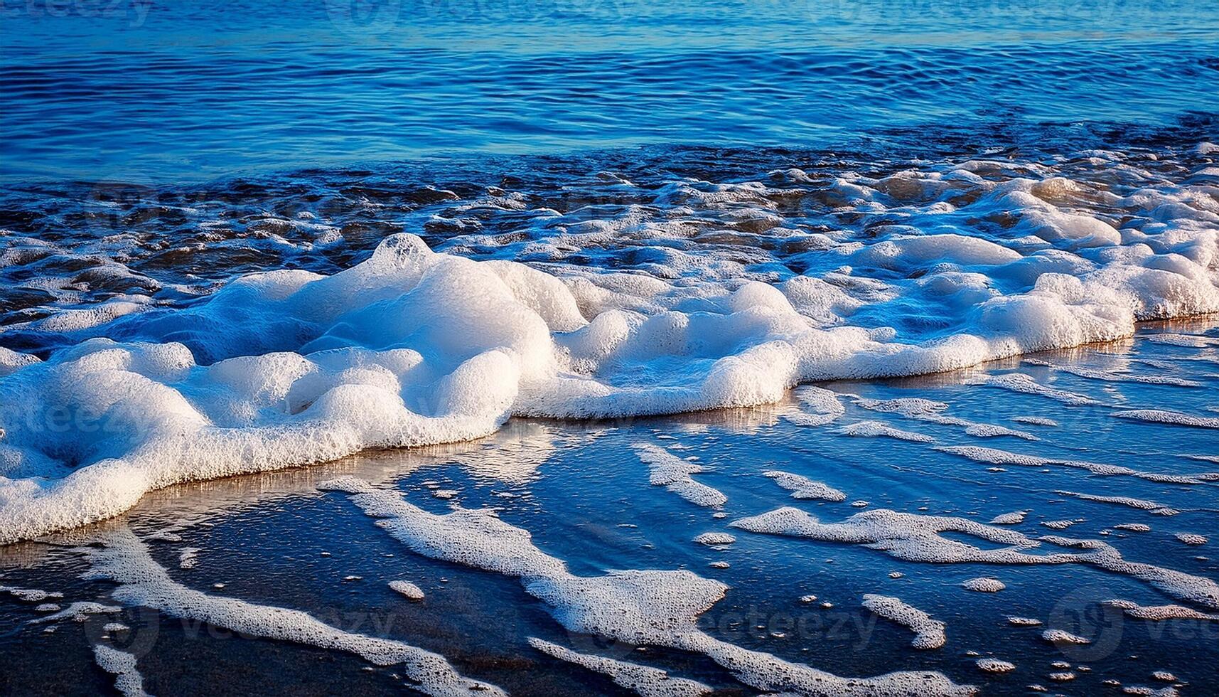 Waves Gently Roll Onto the Sandy Shore at Sunset, Creating a Mesmerizing Display of Foam and Reflections photo