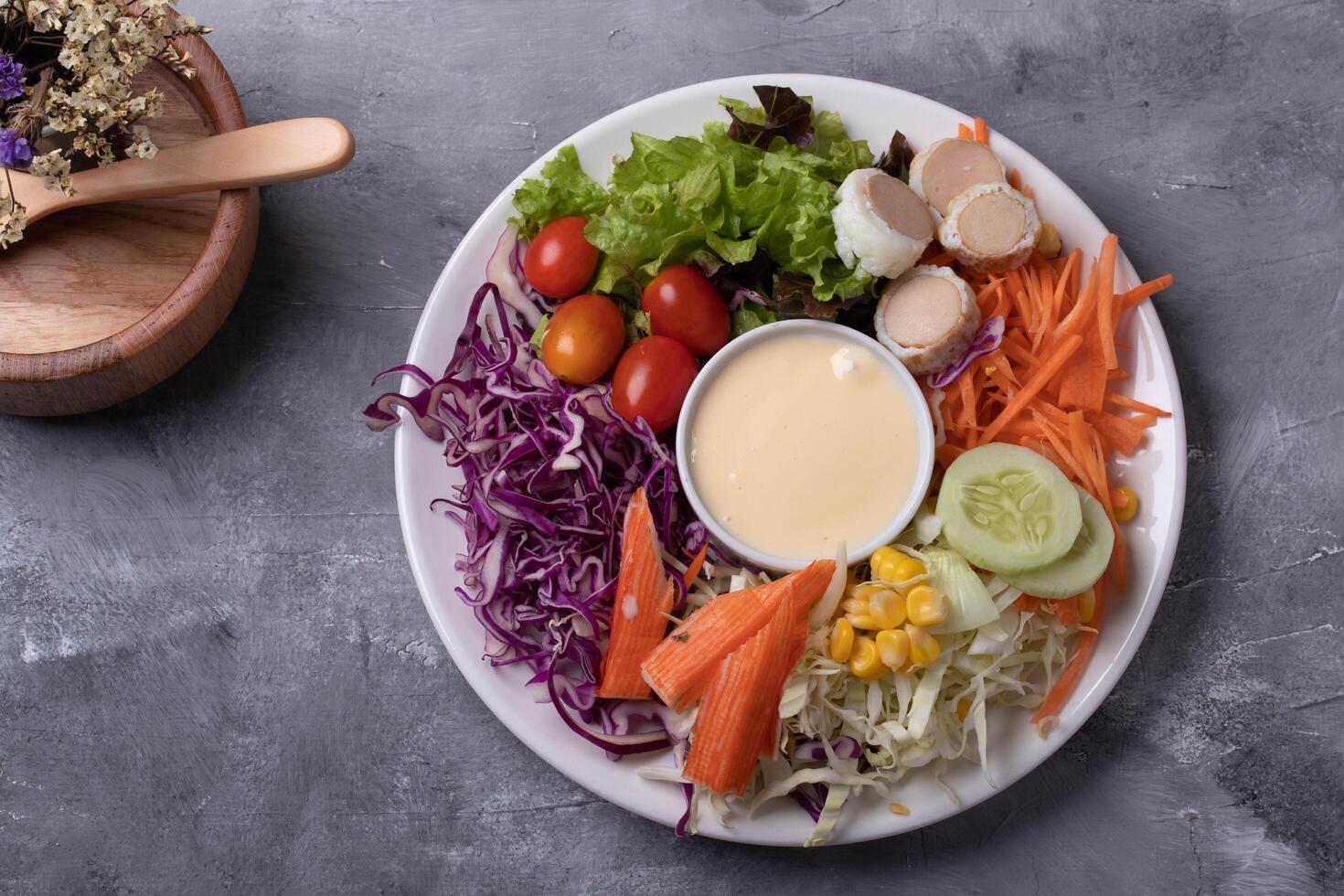 colorful salad plate with fresh vegetables, including lettuce, cherry tomatoes, purple cabbage, carrots, cucumber, corn, and creamy dressing, offers healthy meal option photo