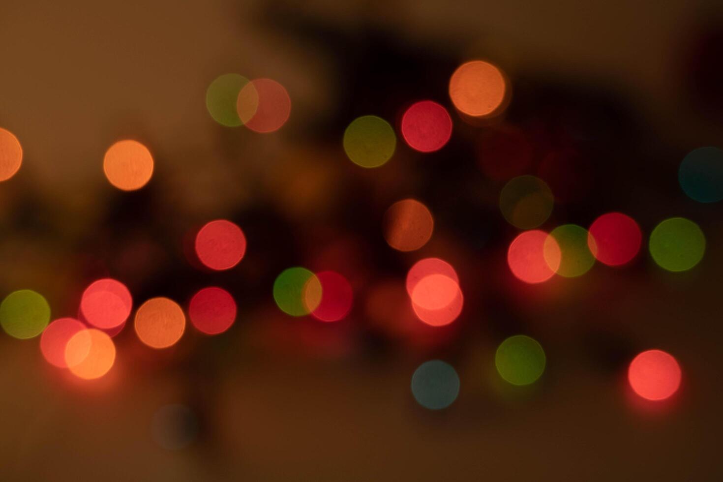 blurred image of colorful bokeh lights creates festive and dreamy atmosphere. soft focus highlights vibrant hues of red, green, orange, and pink, evoking sense of warmth and celebration photo