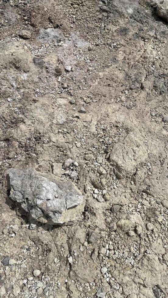 Closeup small stone background. Natural background, cast gravel and sand texture. Ground level view. Texture of gravel and soil for the road. photo