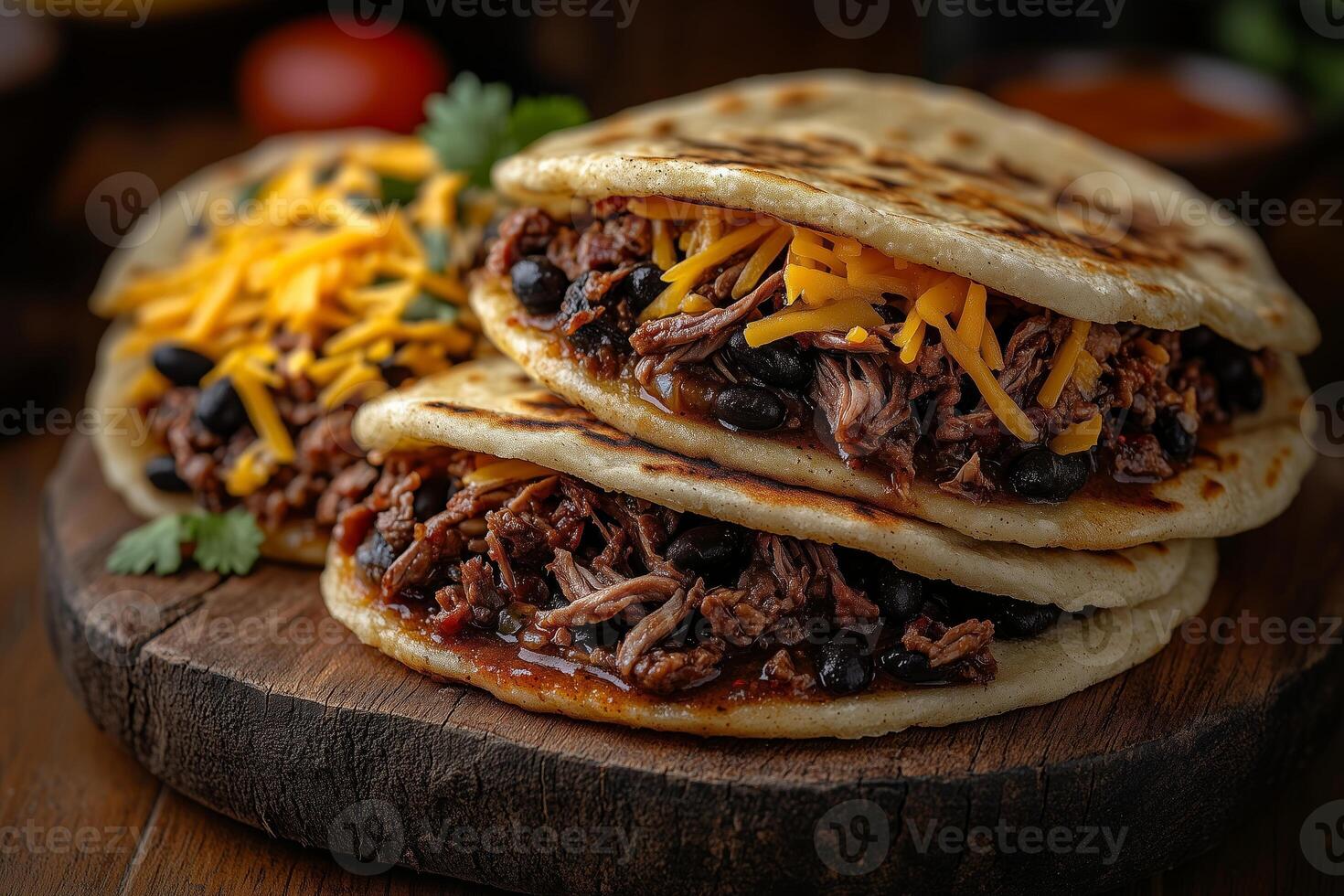 Venezuelan arepas filled with shredded beef, black beans, and cheese, arranged on a rustic wooden plate photo