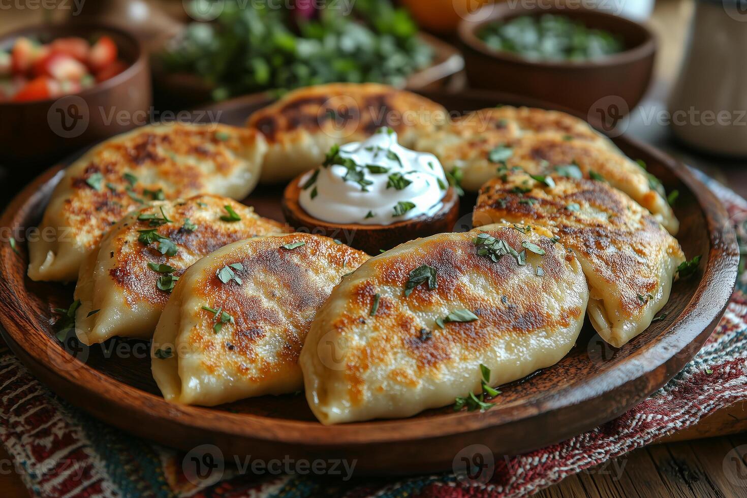 a traditional Eastern European table setting with freshly baked pierogi served on a rustic wooden plate, garnished with sour cream and herbs, surrounded by traditional textiles, soft light photo