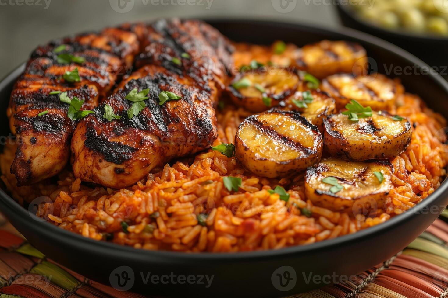 a traditional African meal featuring jollof rice, served with grilled chicken and fried plantains, garnished with fresh herbs, set on a colorful woven mat under natural daylight photo