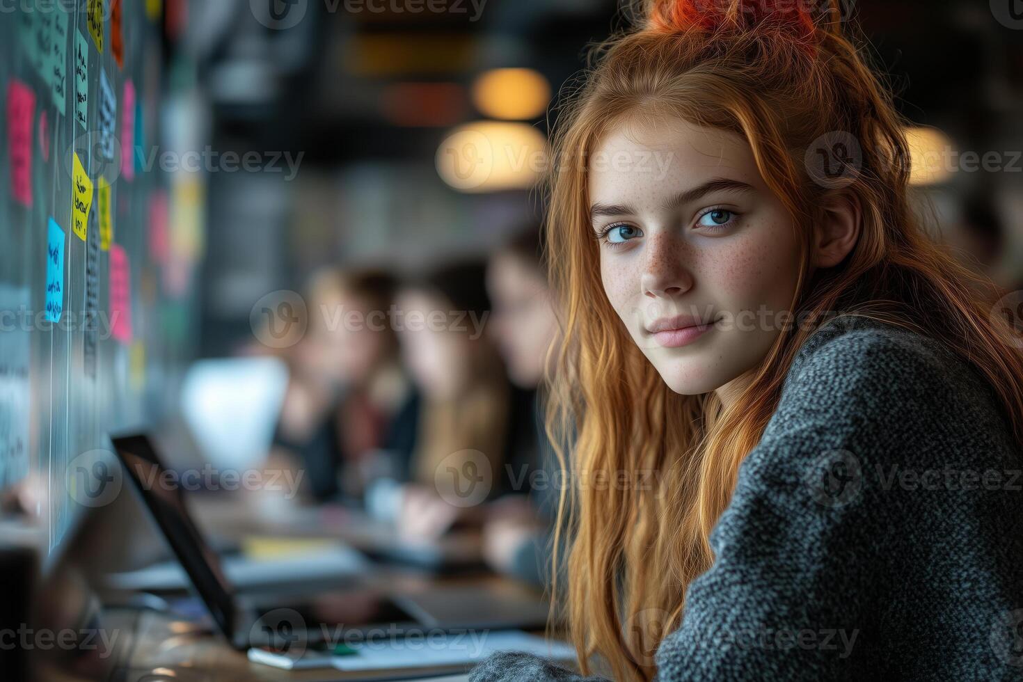 a group of teens brainstorming in a casual office space, writing on a glass board filled with colorful ideas, laptops and tablets on the table, with soft daylight streaming in photo