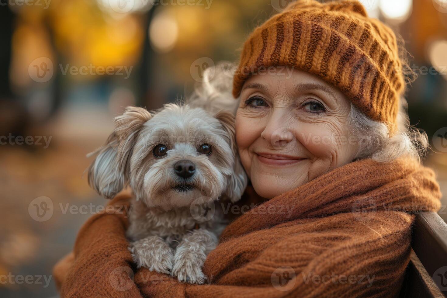 a senior woman embracing her small dog on a park bench, surrounded by autumn leaves, warm afternoon sunlight photo