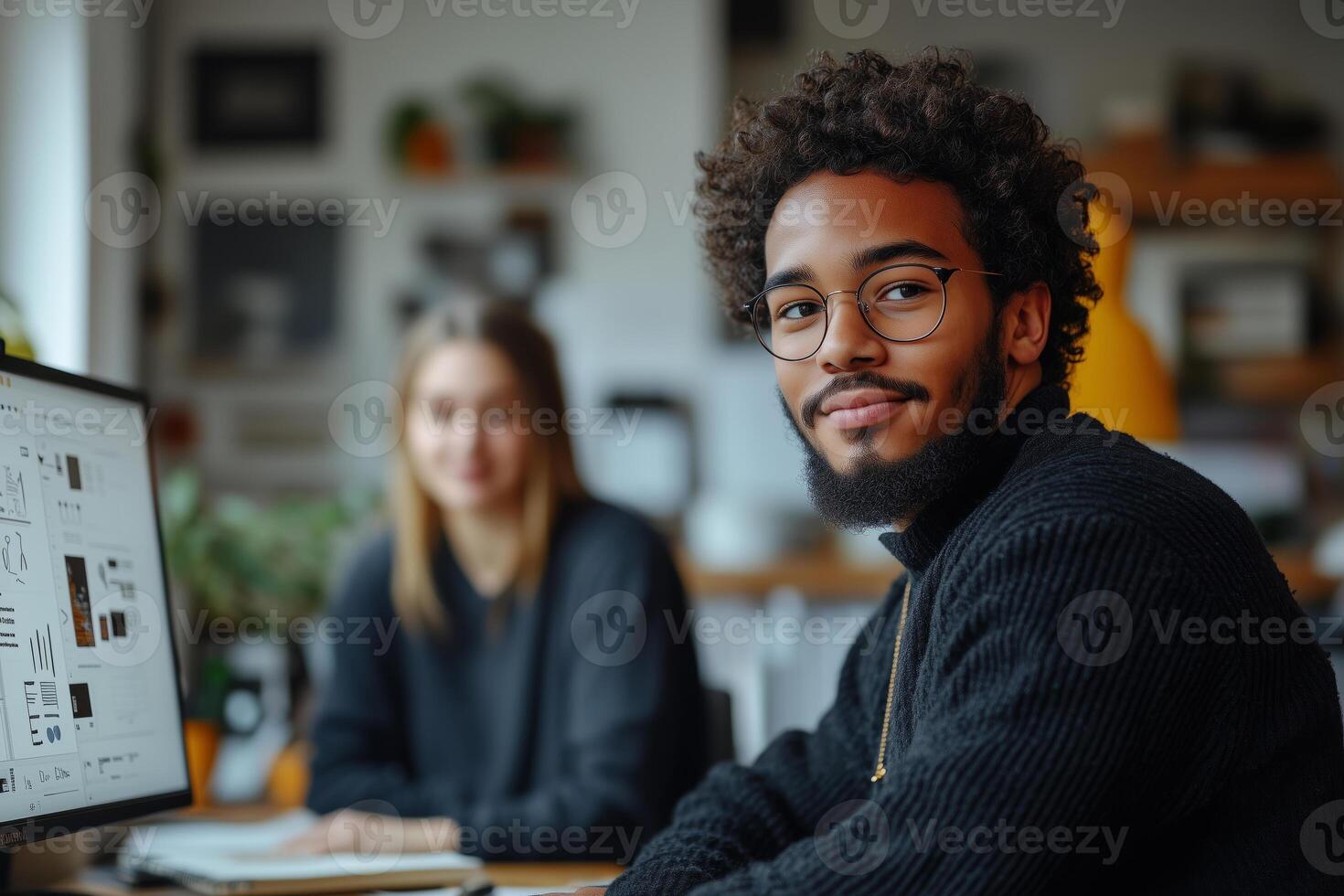 a teen web designer reviewing a wireframe with a mentor, sitting at a desk with dual monitors and notebooks filled with ideas photo