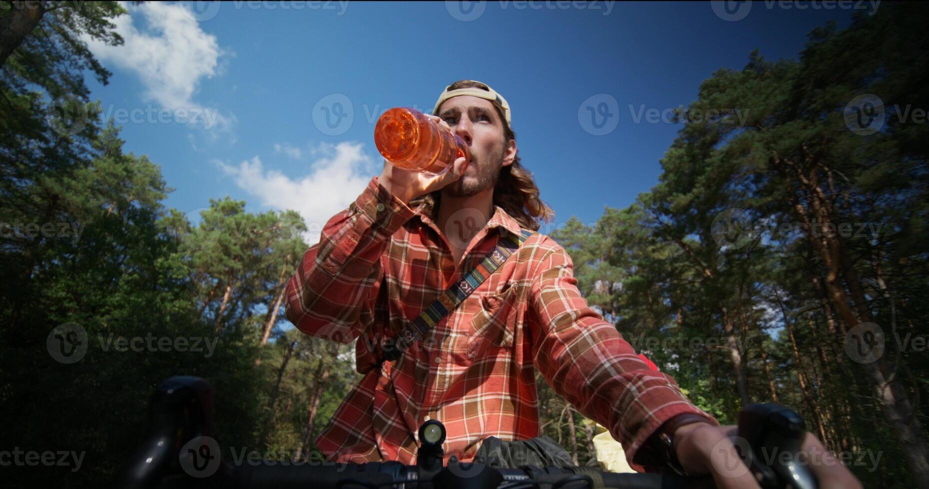 A man on a bicycle drinking from a bottle photo