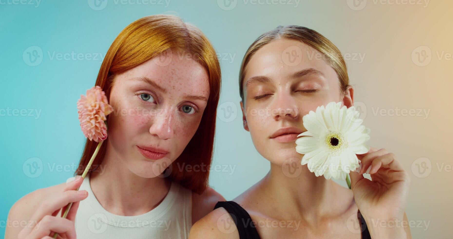 Two women holding flowers and looking at each other photo