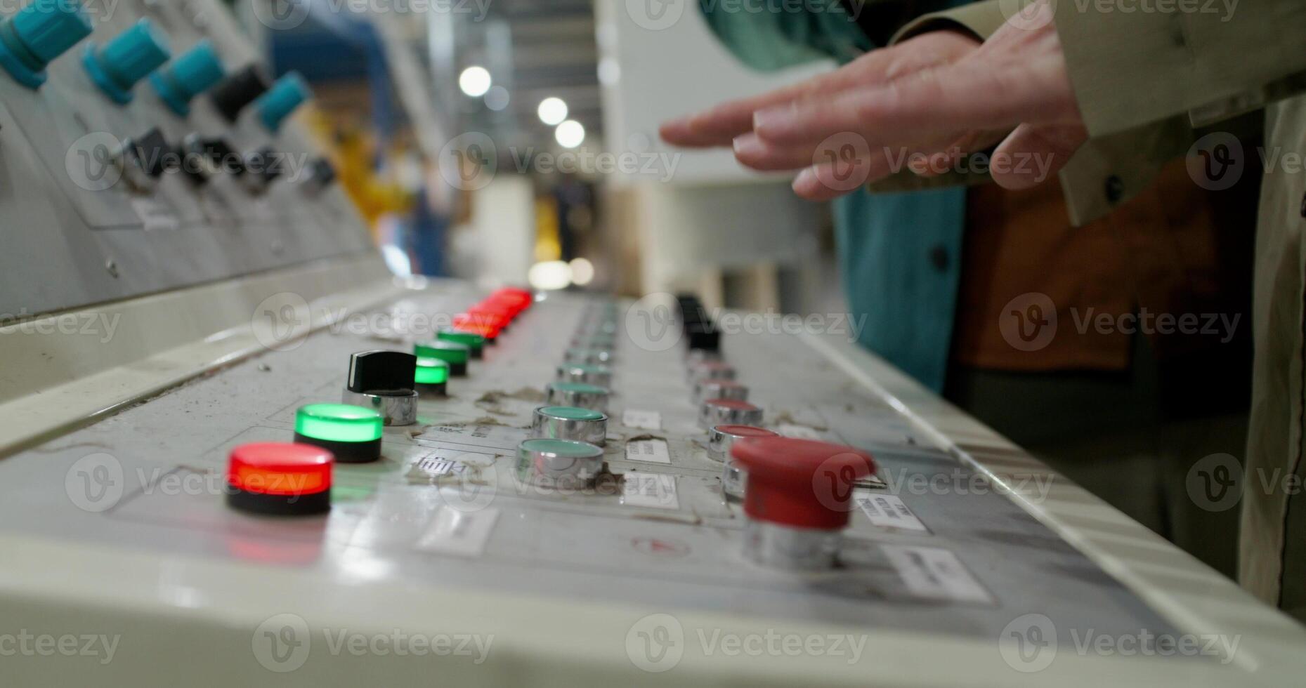 A person is standing in front of a control panel photo