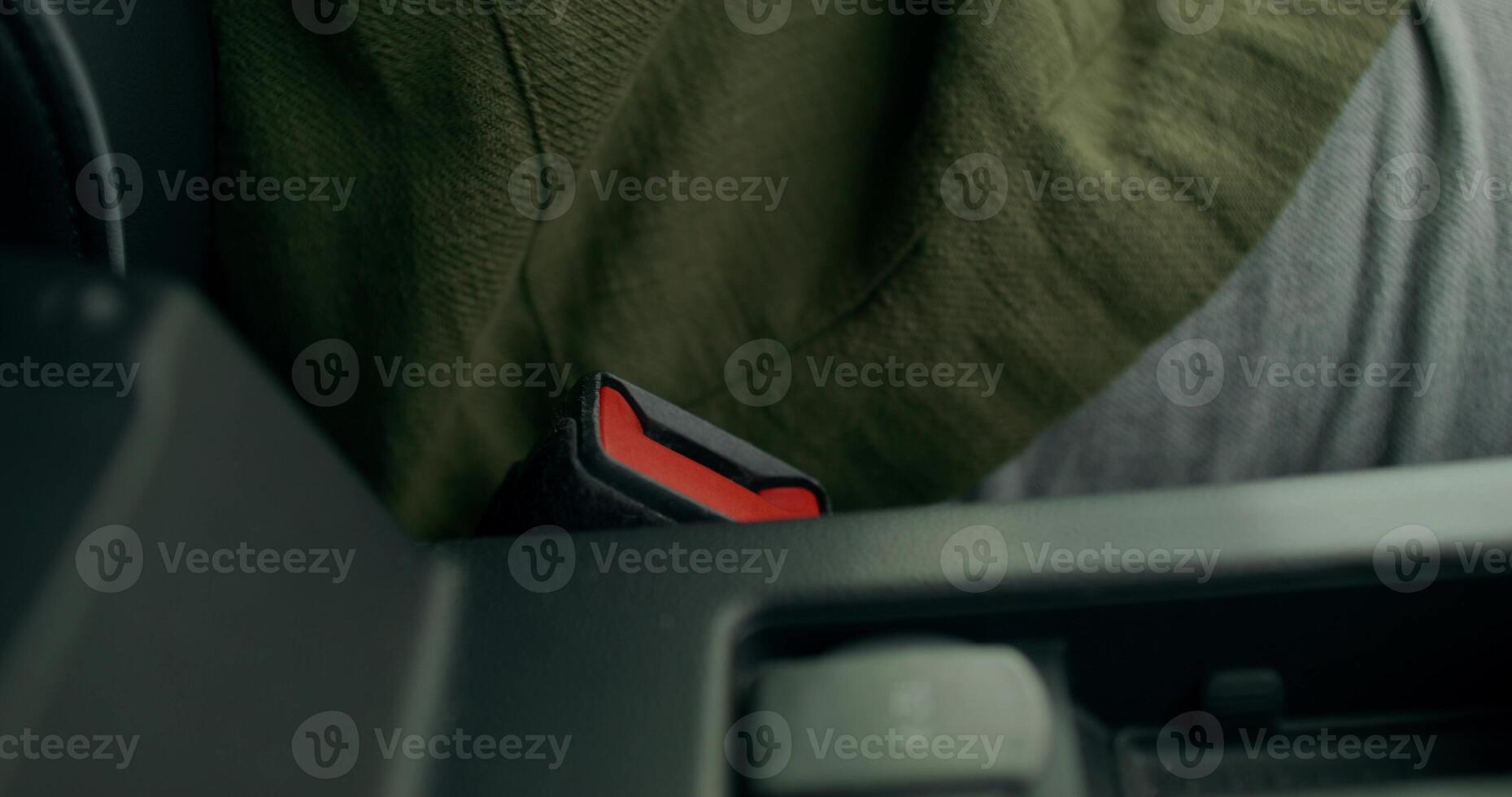 A person's hand is holding a red button on the side of a car photo