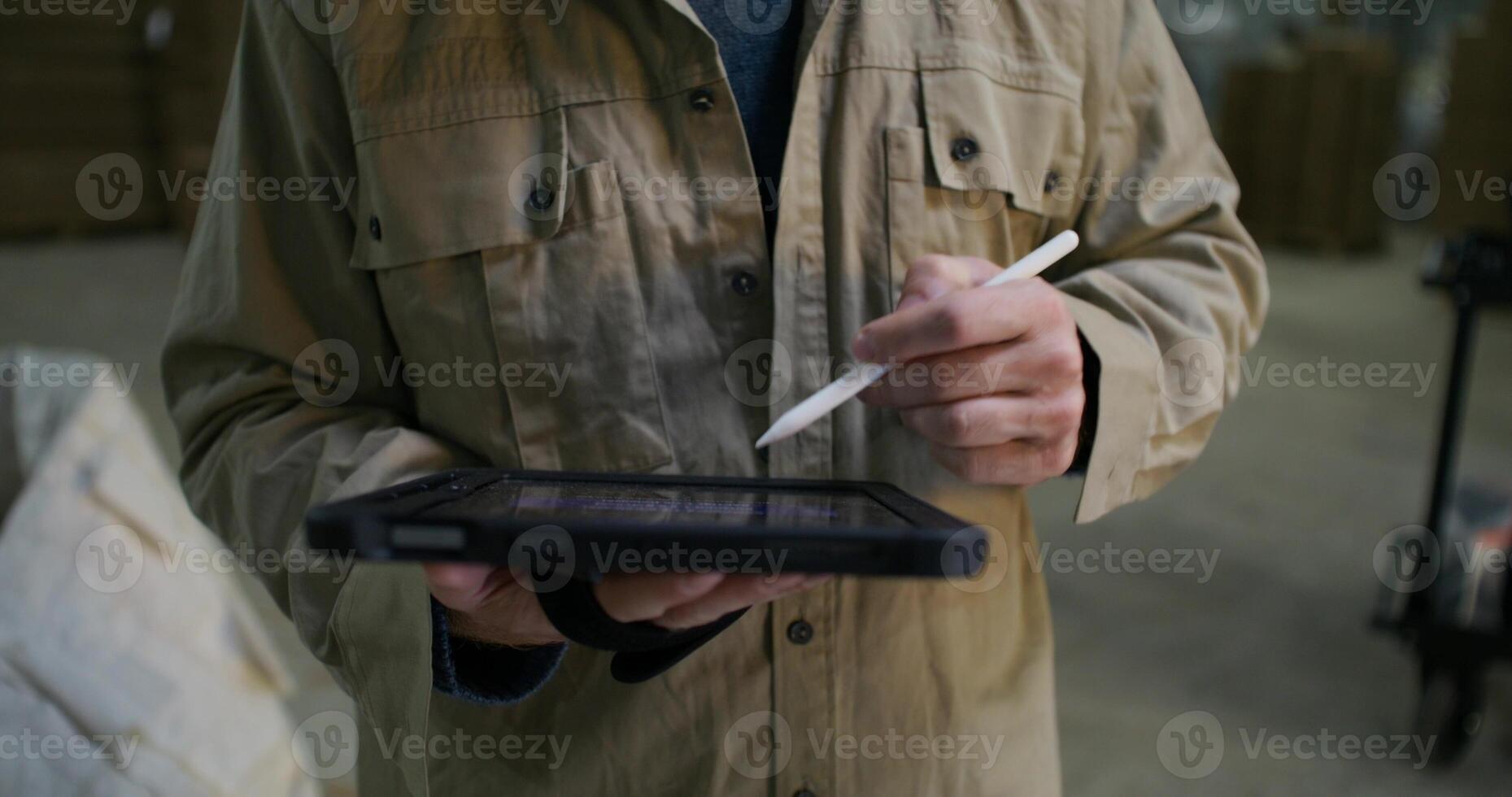 A man in a jacket holding a pen and tablet photo