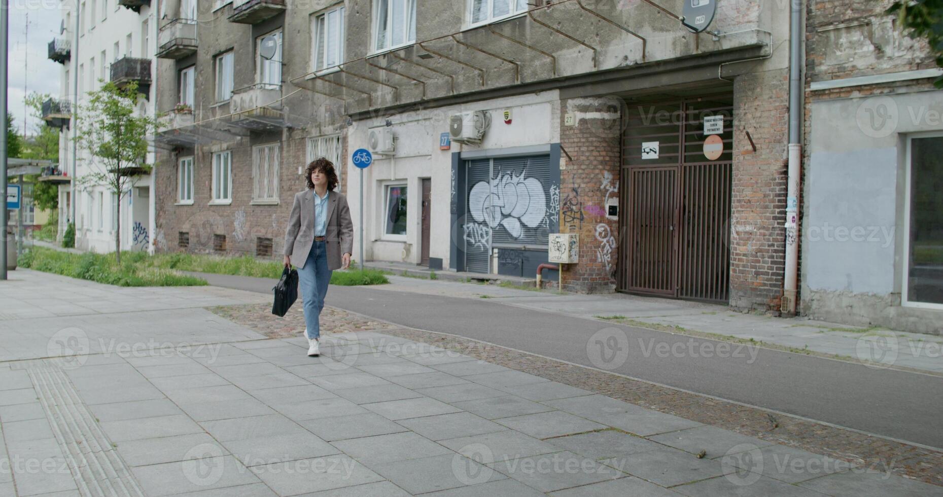 A woman walking down the street in front of buildings photo