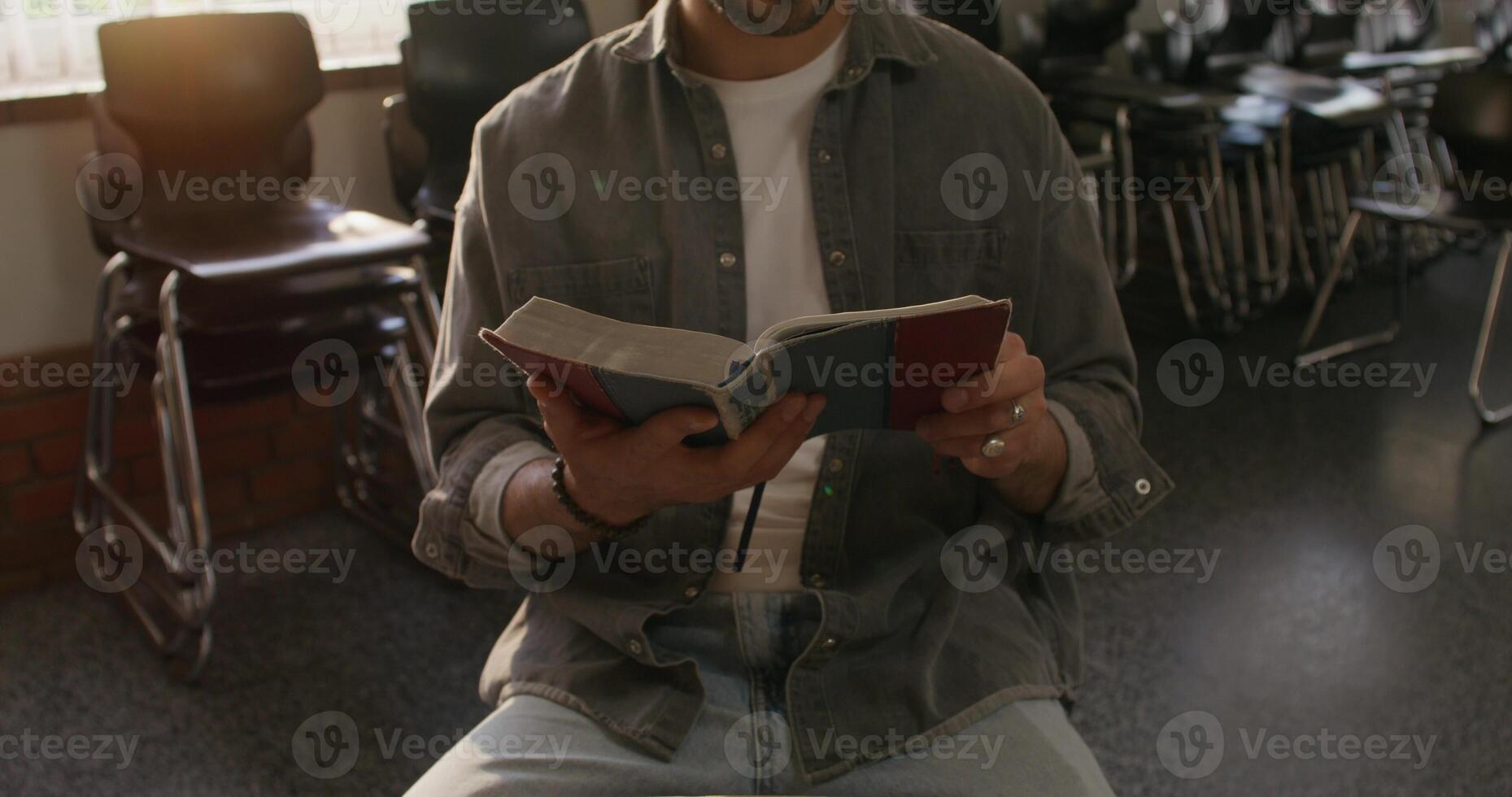 A man sitting in a chair reading a book photo