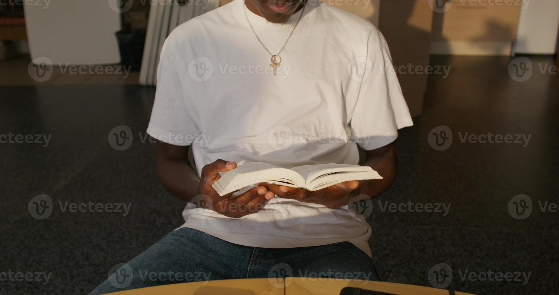 A man sitting at a table with a book photo
