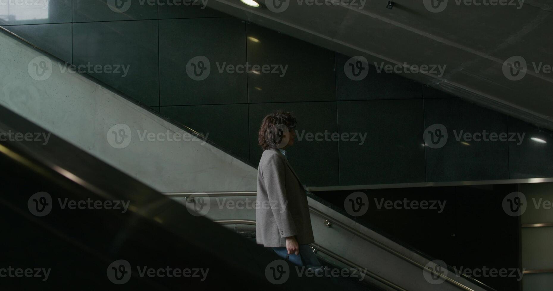 A man walking down an escalator in an empty building photo